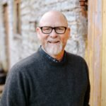man in black crew neck sweater wearing black framed eyeglasses